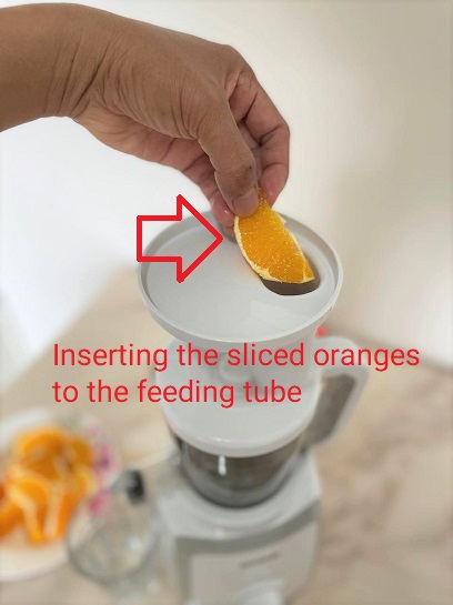 What is cold press slow juicer machine -  feeding oranges to slow juicer